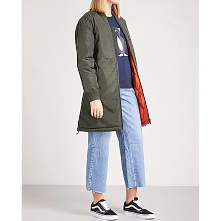 Side view of the CHOCOOLATE Reversible Two-Tone Shell Coat with the green side outward. The lightweight shell design includes a stand collar, quilted detailing, and buttoned flap pockets, offering a minimalist yet stylish look.