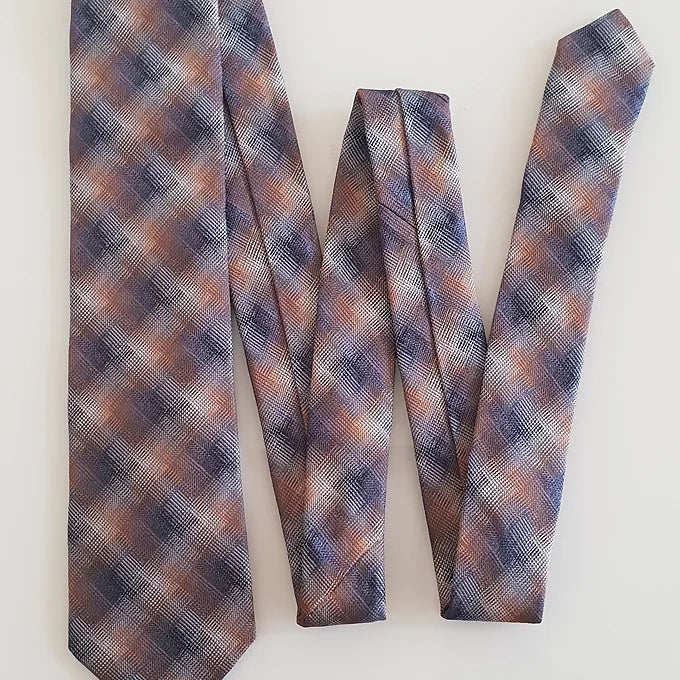 A full-length view of the Duchamp Abstract Check Tie arranged in a zigzag or folded “W” shape. This display highlights the tie’s sleek design, vibrant autumnal tones, and premium silk construction.