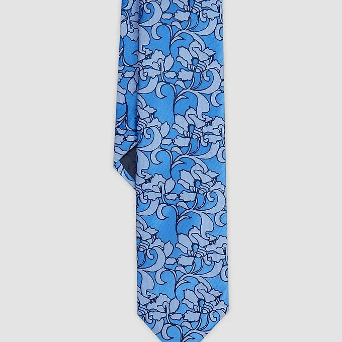 Close-up of the front tip of the Duchamp London Abstract Garden Tie in blue, highlighting the intricate abstract garden pattern and the smooth, premium silk fabric.