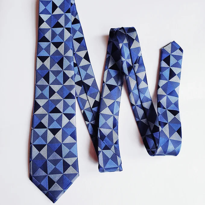 Duchamp London Blue Geometric Silk Tie folded into a W shape, creating a dynamic display of the intricate geometric pattern on the luxurious blue silk fabric.