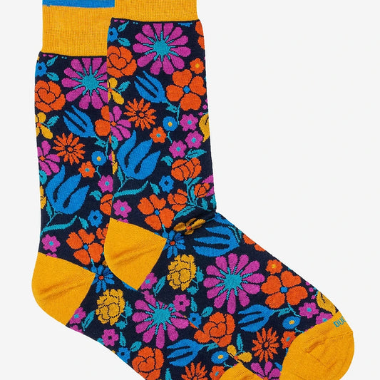 Pair of Duchamp London Botanical Floral Socks in yellow, displayed from a bird’s eye view. One sock is placed slightly on top of the other, revealing the bold botanical floral design, contrast heel, and toe details.